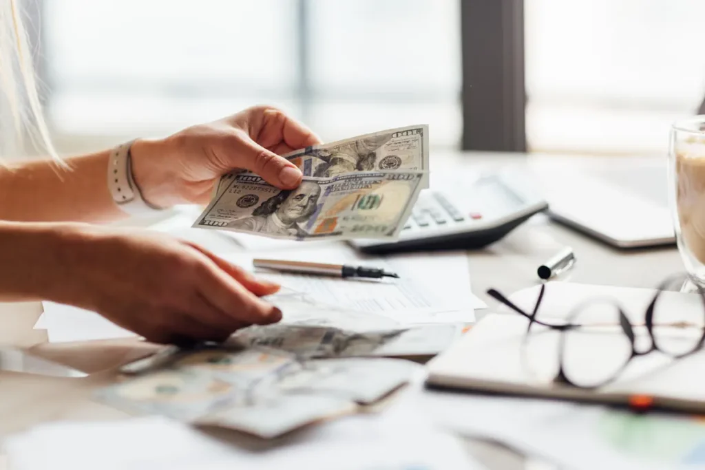 Une personne qui compte des billets d'argent sur une table