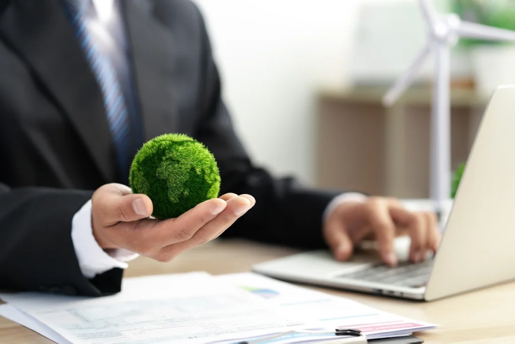 Un homme sur ordinateur en tenant une boule verte dans son autre main