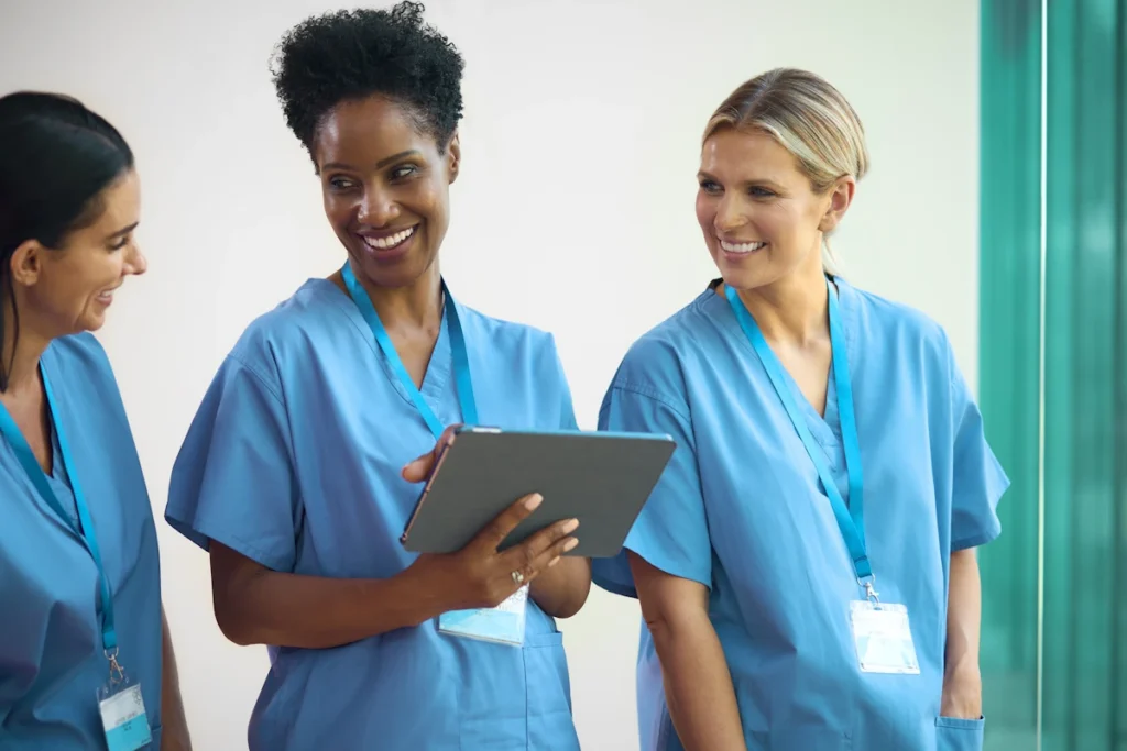 Trois femmes en blouse bleu qui discutent et rient ensemble