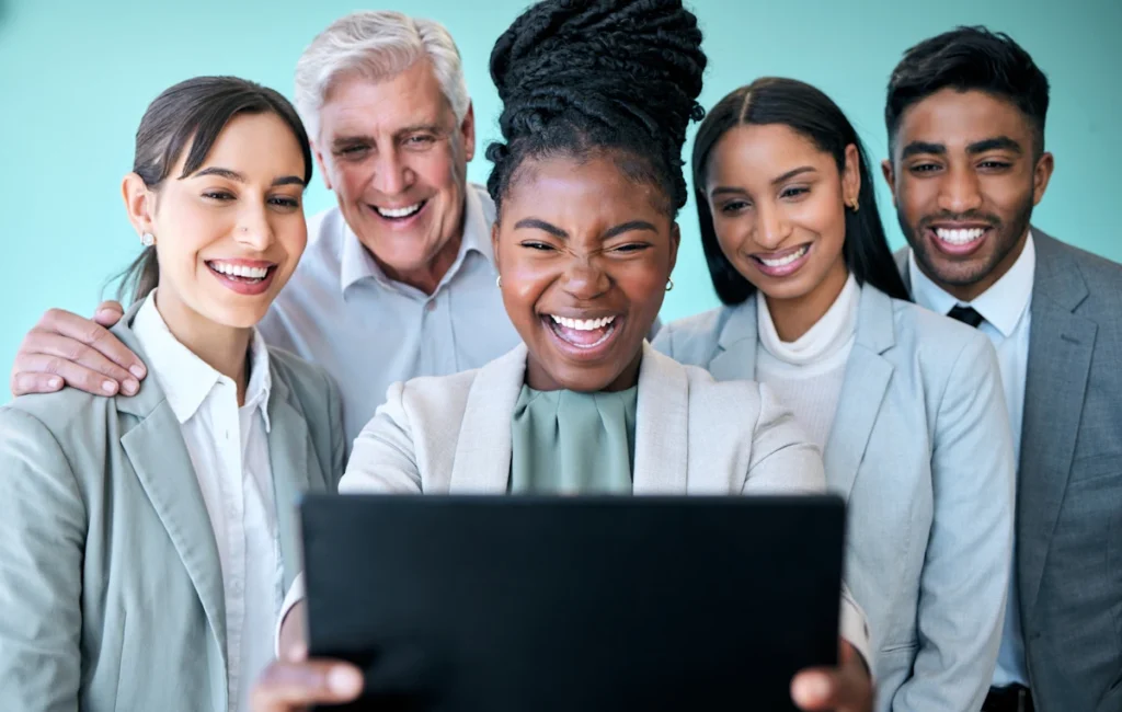 Un groupe de personne en tenue de travail qui prenne une photo avec une tablette
