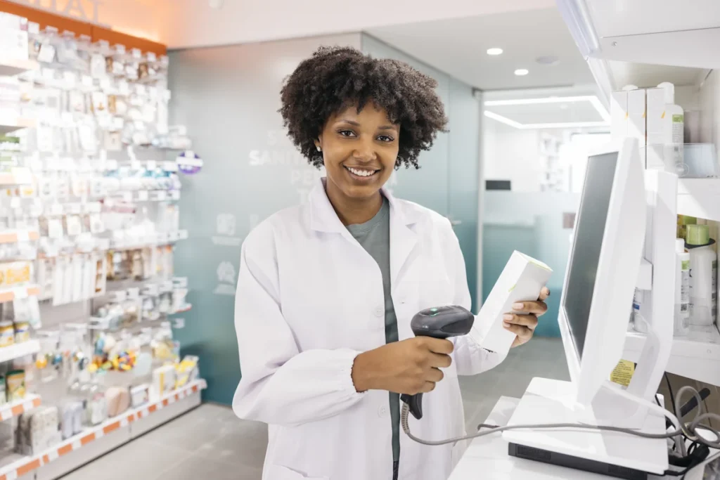 Une femme en blouse dans une pharmacie qui scanne un produit