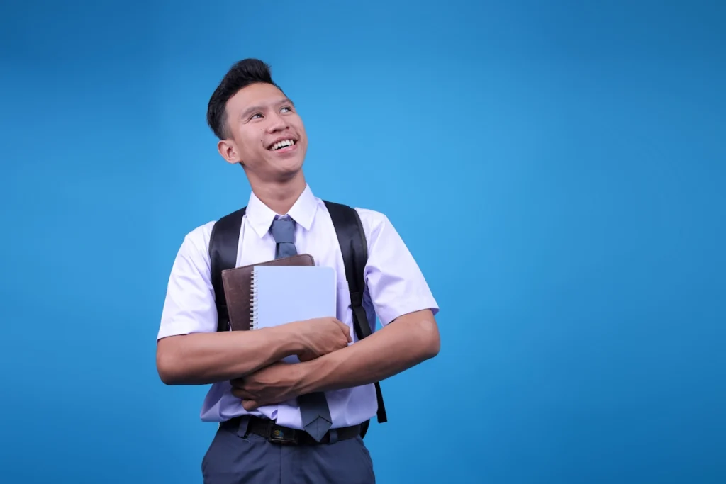 Un jeune homme en cravate et chemise qui porte des cahiers et un sac à dos