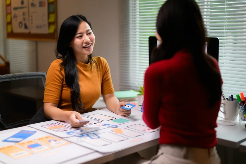 deux jeunes femmes qui discutent autour d'un bureau