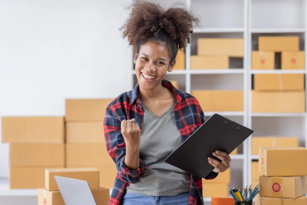 une femme qui sourit en tenant un carnet
