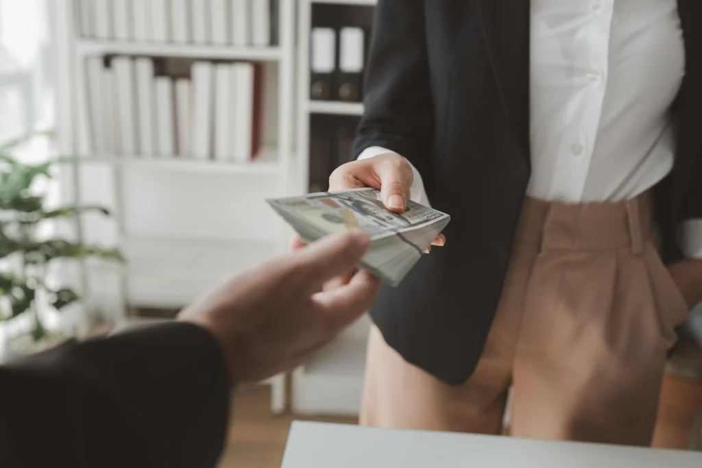 Une femme qui prend de l'argent tendu par un homme