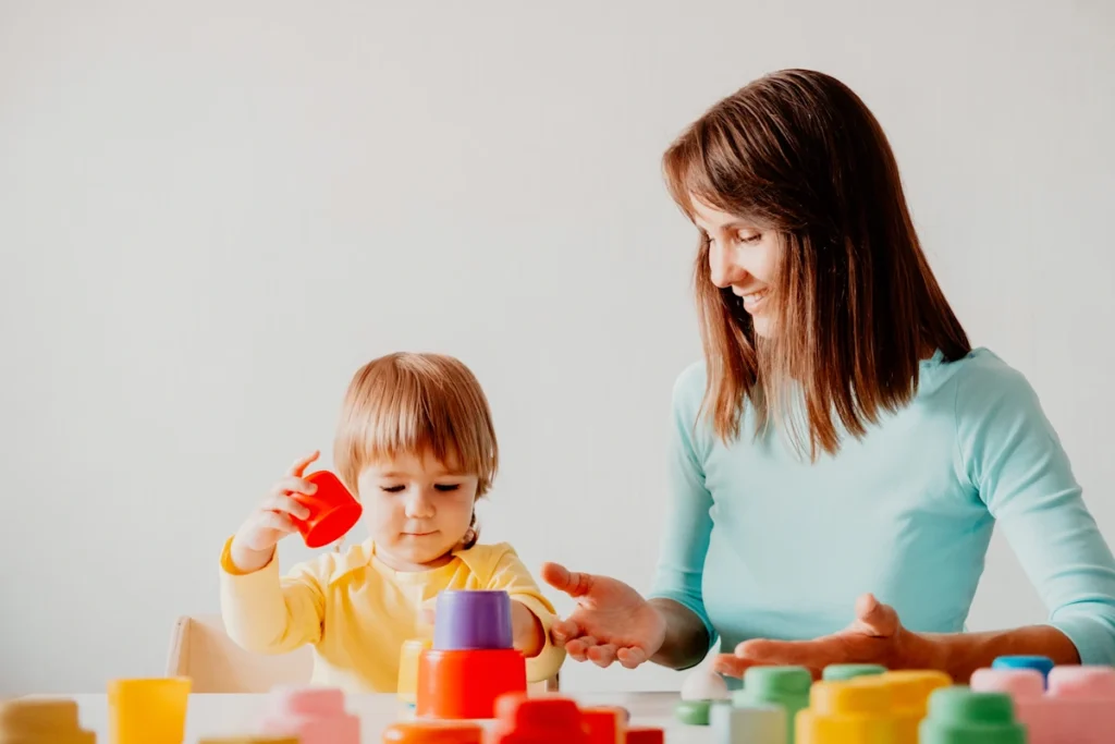 Une femme qui joue avec un enfant avec des cubes colorés