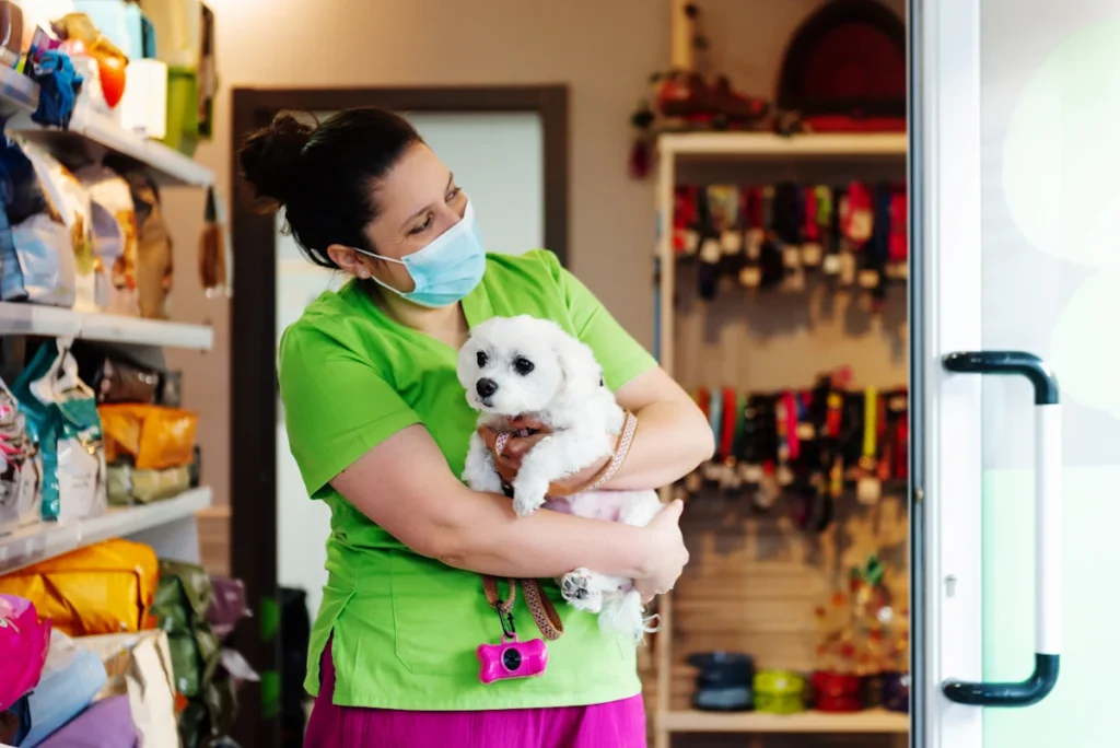 Une femme avec un chien dans les bras dans une boutique d'animalerie