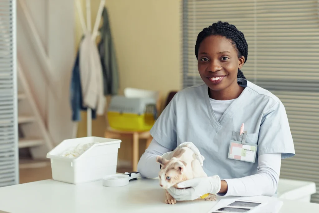 Une femme en blouse qui tient un chat dans ses mains