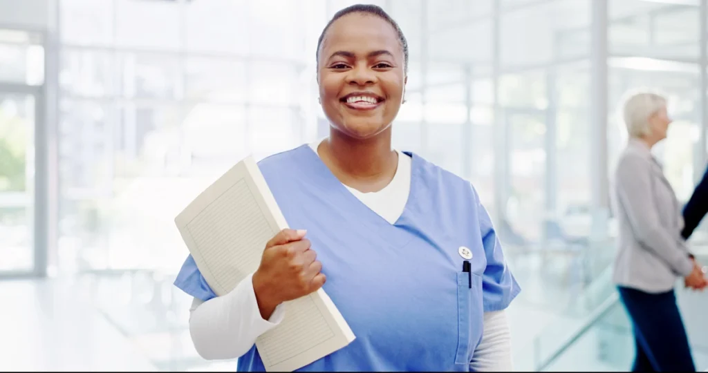 Une femme aide soignante en blouse qui tient un document dans sa main