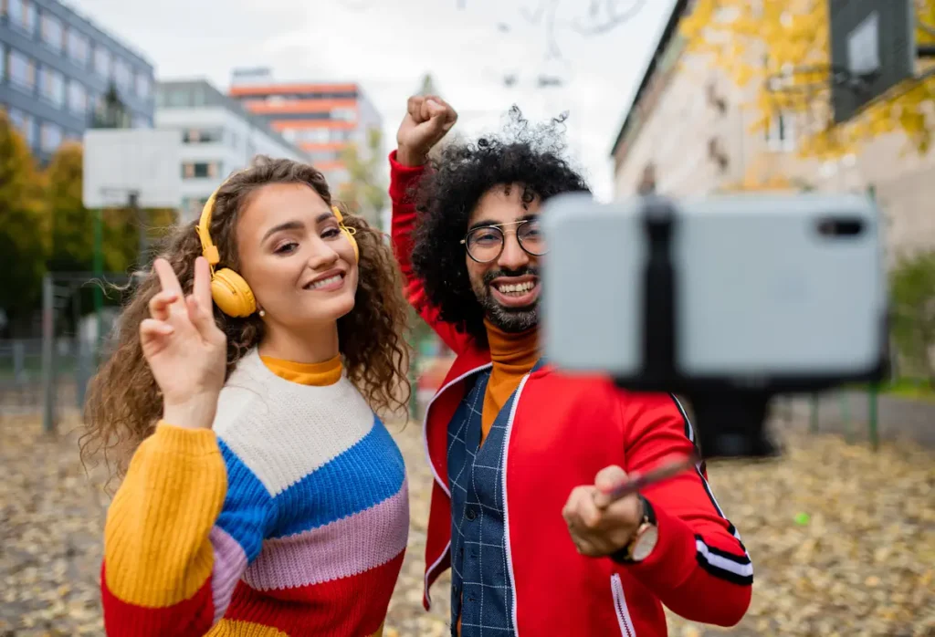 Un homme et une femme qui se filment avec un Smartphone