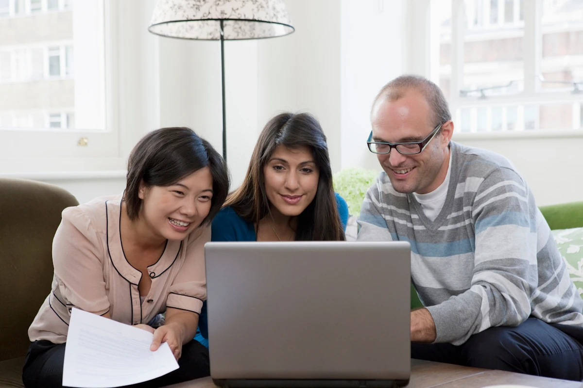 Deux femmes et un homme qui regarde un ordinateur