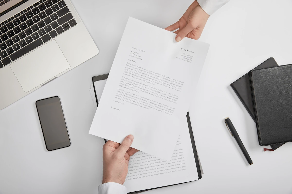 Une personne qui tend une lettre de motivation à une autre