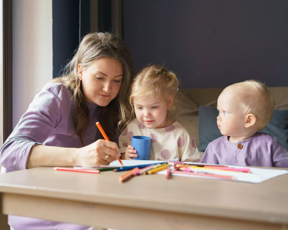 Une femme qui écrit à côté de deux petits enfants