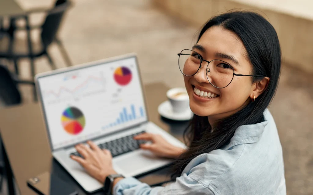Une femme qui travaille sur son ordinateur avec des illustrations statistiques sur l'écran