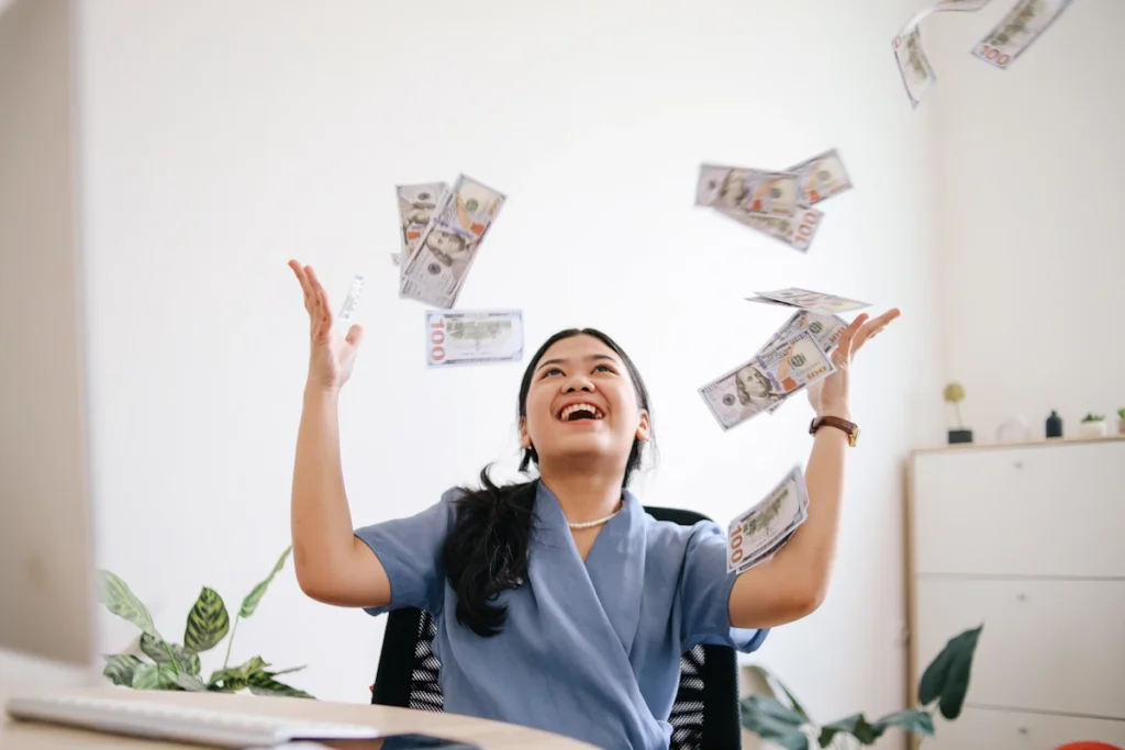 Une femme contente qui jette de l'argent en l'air