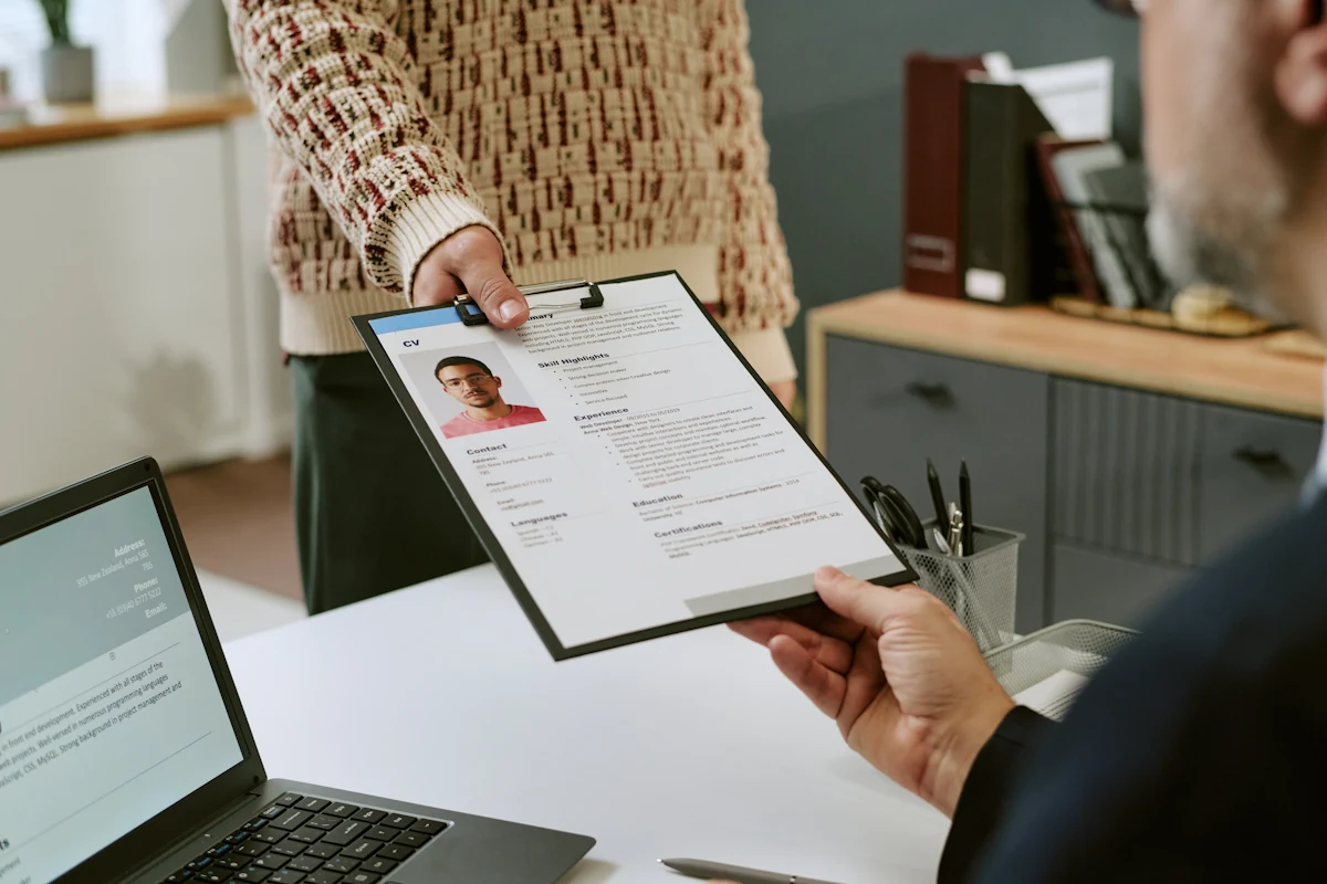 Une personne qui tend un CV 1 page à une autre