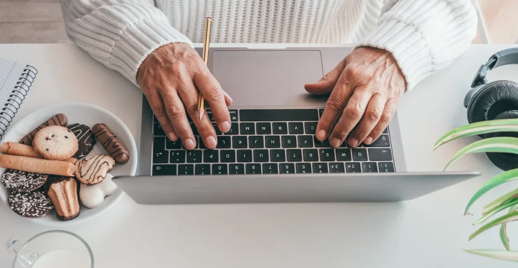 Une personne qui rédige un article de blog sur un ordinateur