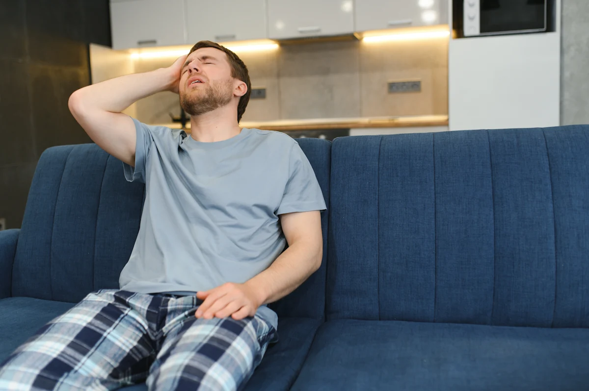 Un homme fatigué assis dans le canapé