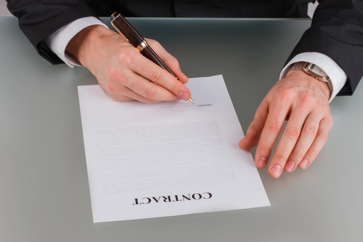 Un homme qui signe un contrat de rupture conventionnelle