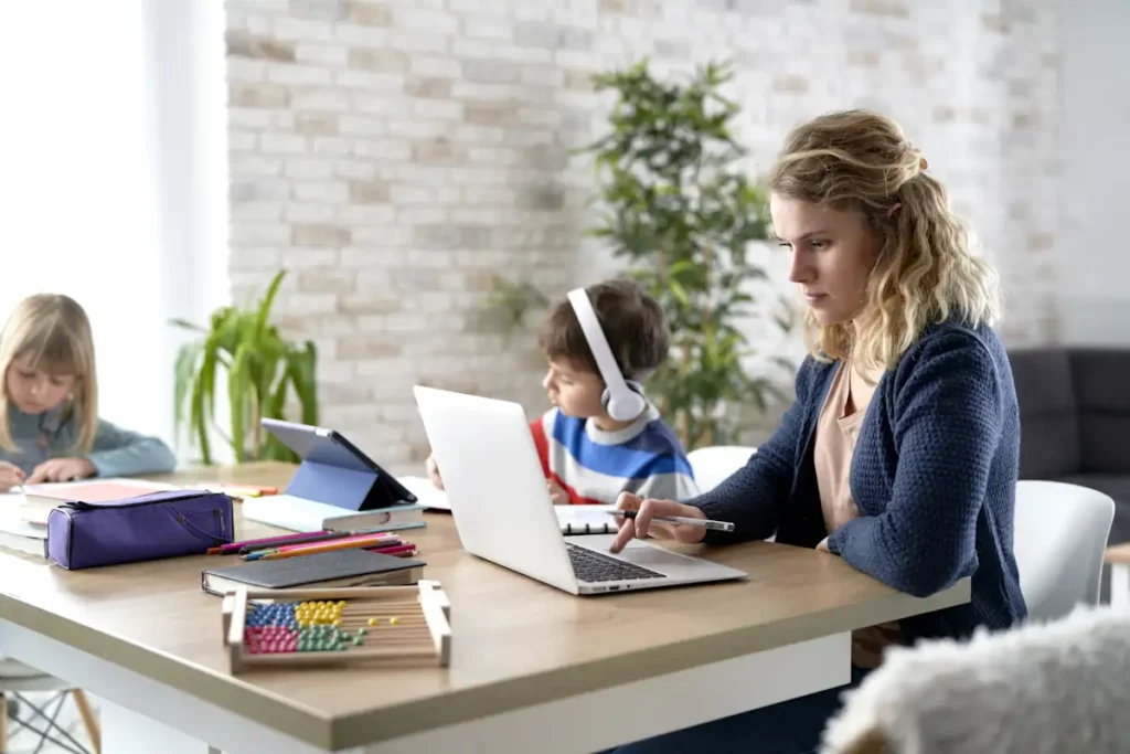 Une maman en télétravail avec ses enfants à côté